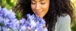 A woman smelling fresh flowers—an example of tangible appreciation ideas that engage the senses and leave a lasting impression.